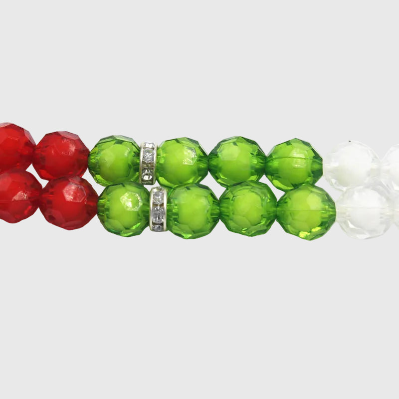 Close-up of red, green, and white beaded bracelet on a white background